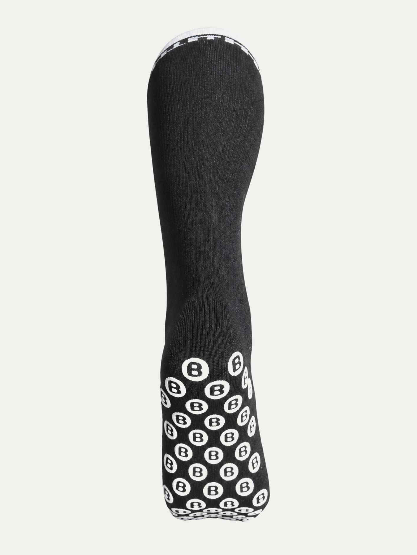 Sole of the long Bulletproof grip sock, covered in white B-logo silicone grip dots.