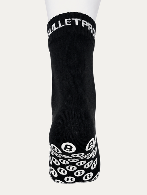 Short Bulletproof grip sock seen front on, BULLETPROOF knitted into the cuff and the B-pattern grip dots visible along the sole.