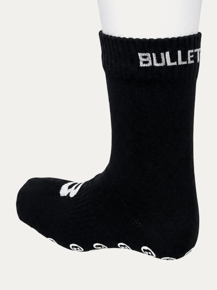 Short Bulletproof grip sock from the side, showing the ribbed cuff and the row of grip dots running along the base of the sole.